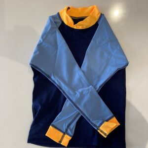 Blue and navy color-block garment with an orange inner collar laid flat on a light surface (folded scarf/shawl).