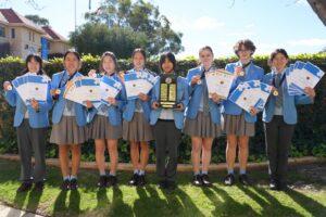 Da Vinci Decathlon 1 - St Hilda's Anglican School For Girls Year 9 da Vinci Decathlon team with their certificates, trophy and medals.
