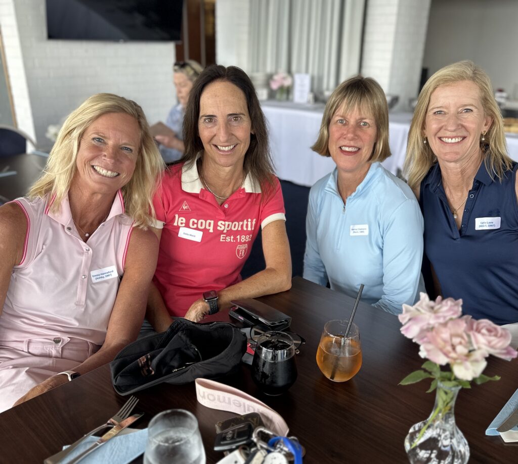 IMG_2215 - St Hilda's Anglican School For Girls Four women posing for a group selfie at a table, smiling, with drinks and name tags in view.