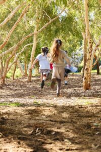 145 St Hildas Primary 270723 JWyld - LR - St Hilda's Anglican School For Girls Students running through nature play area.