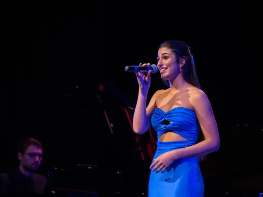 Solo vocalist performing under stage lights during music festival at a high schools in Perth
